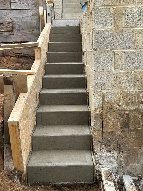 Fresh concrete front steps and entry landing at a residential home.