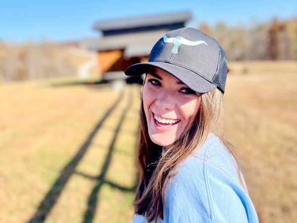 Person wearing GRAB'EM BY THE HORNS baseball cap
