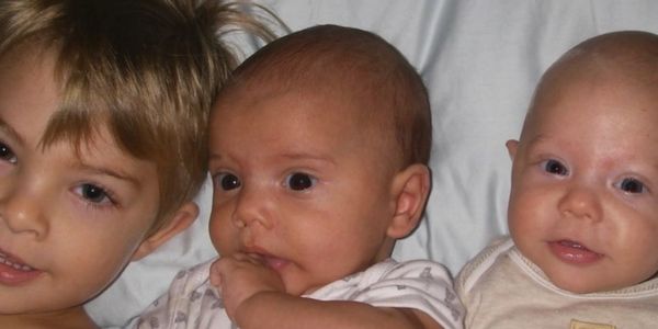 A toddler boy with his baby twin brothers