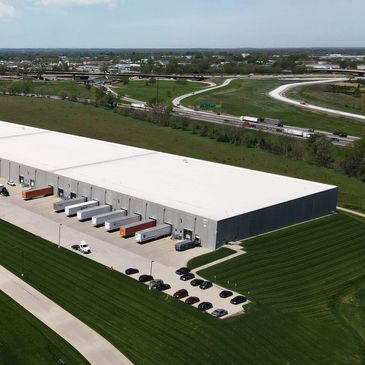 An exterior view of a warehouse with freshly mowed grass and meticulous lines from the mower.