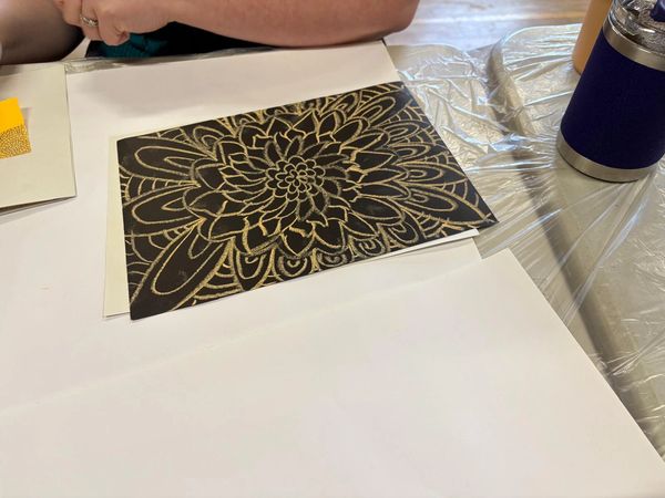 Gold floral drawing on black paper.