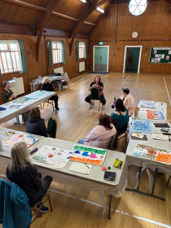 Group art therapy session in a wooden hall.