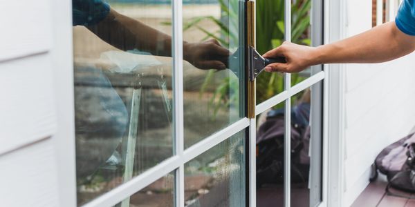 A photo of someone cleaning a window by hand with a squeegee