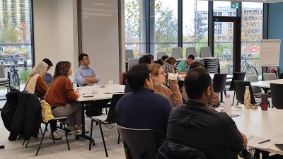 Group of people attentively listening in a modern seminar room.