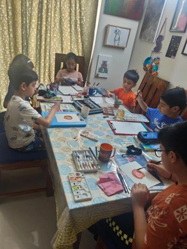 Children engaged in a painting session at a table.