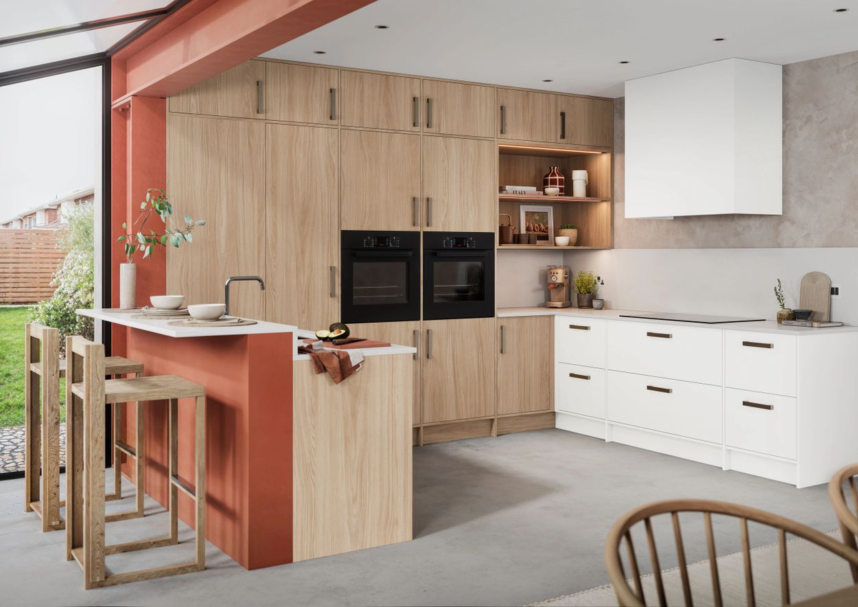 Modern kitchen with wood and white cabinetry, a breakfast bar, and large windows overlooking a garden.