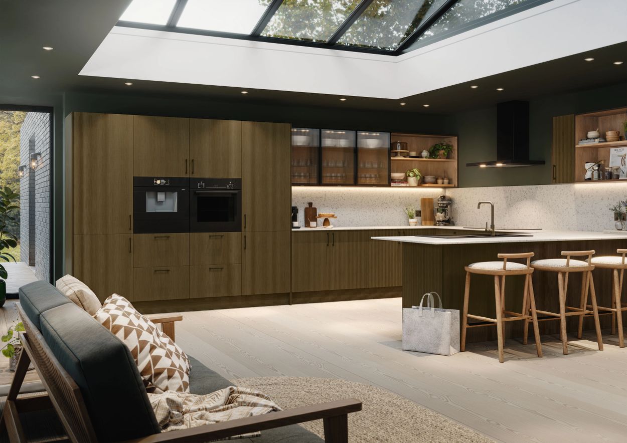 Modern kitchen with skylight, olive green cabinets, and wooden bar stools.