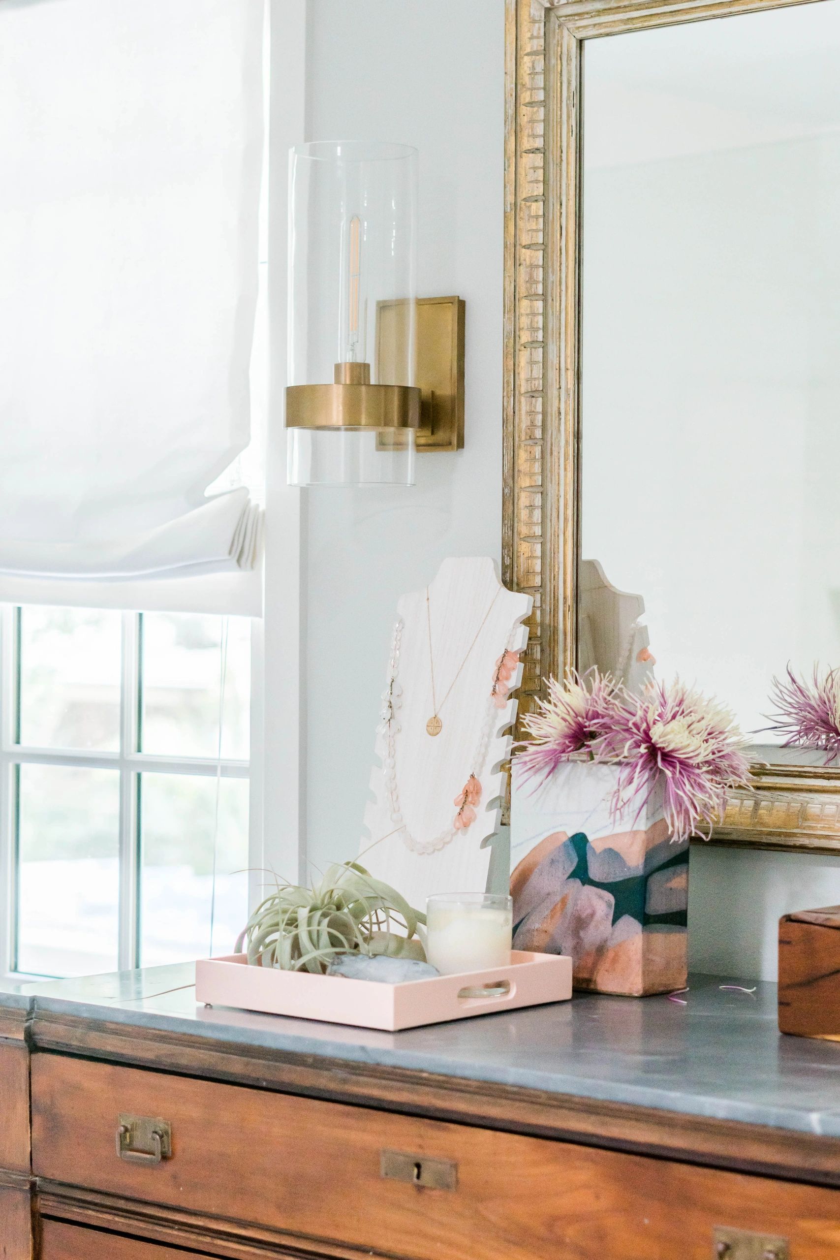 Transitional bathroom with vintage dresser and brass wall sconce in Austin, TX