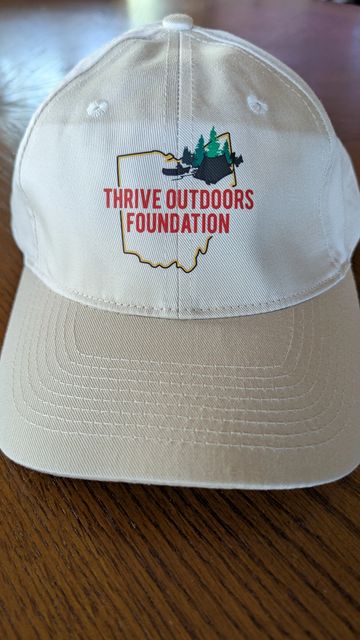 Beige cap with Thrive Outdoors Foundation logo.