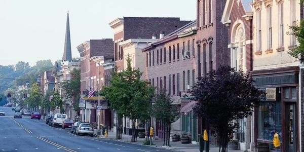 Historic small-town street with brick buildings and parked cars.