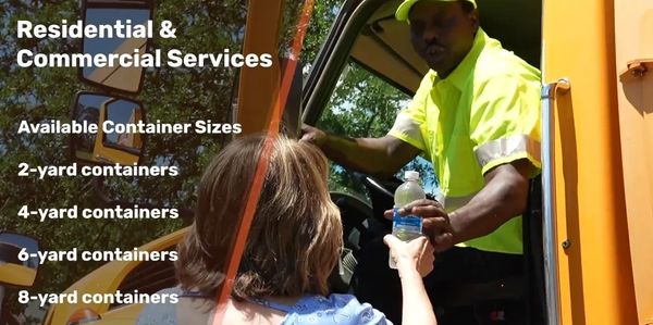 Worker handing a water bottle to a woman from a truck window.