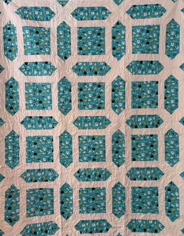 Quilt with teal patterned fabric squares and rectangles.