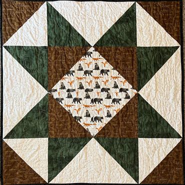 Quilt with a star pattern and bear fabric.