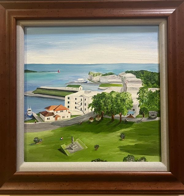 Framed painting of a coastal town with green lawns and buildings.