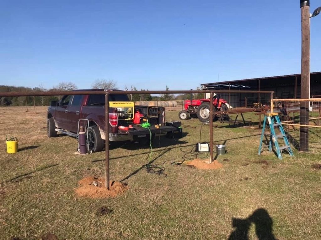 Rural outdoor workspace with truck, tractor, and welding setup.