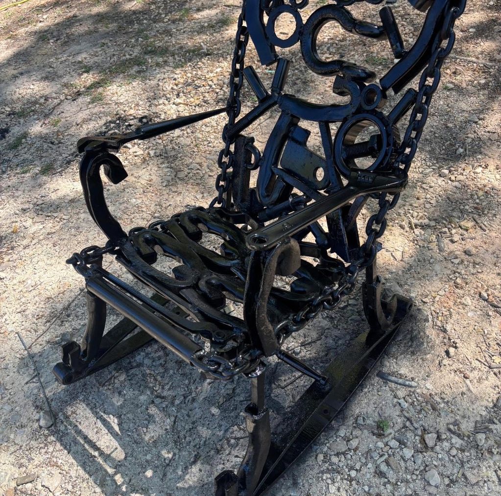 Black metal rocking chair made from various mechanical parts.