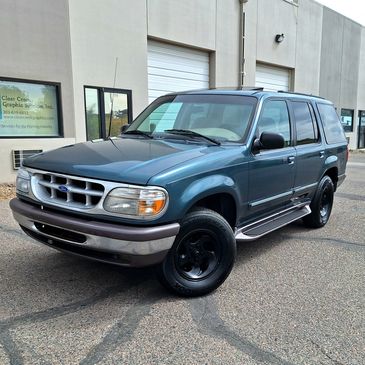 A blue Ford SUV parked outside a commercial building.