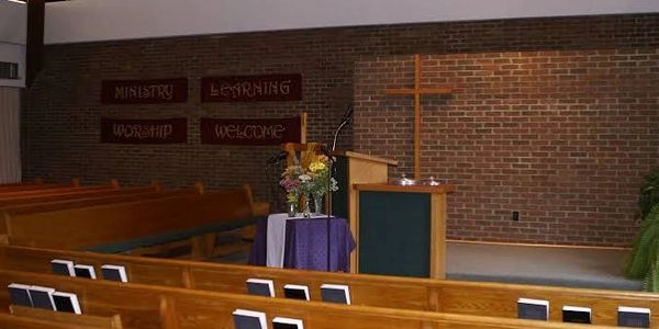 Empty church interior with wooden pews and a podium.