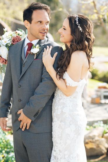 Bride and groom sharing a joyful moment on their wedding day outdoors.