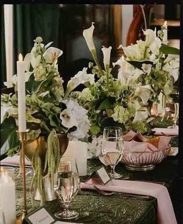 Elegant table setting with white flowers, candles, and glassware.