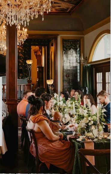 Elegant dinner party with guests enjoying a beautifully decorated table in a vintage setting.