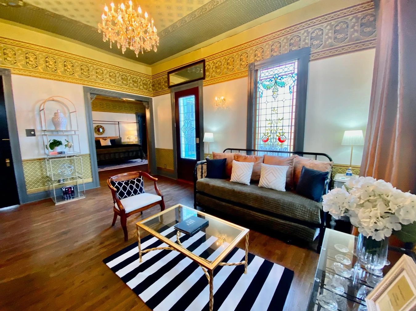 Elegant living room with vintage decor and stained glass window.