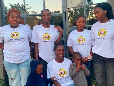 Group photo of six people wearing white shirts with a logo.