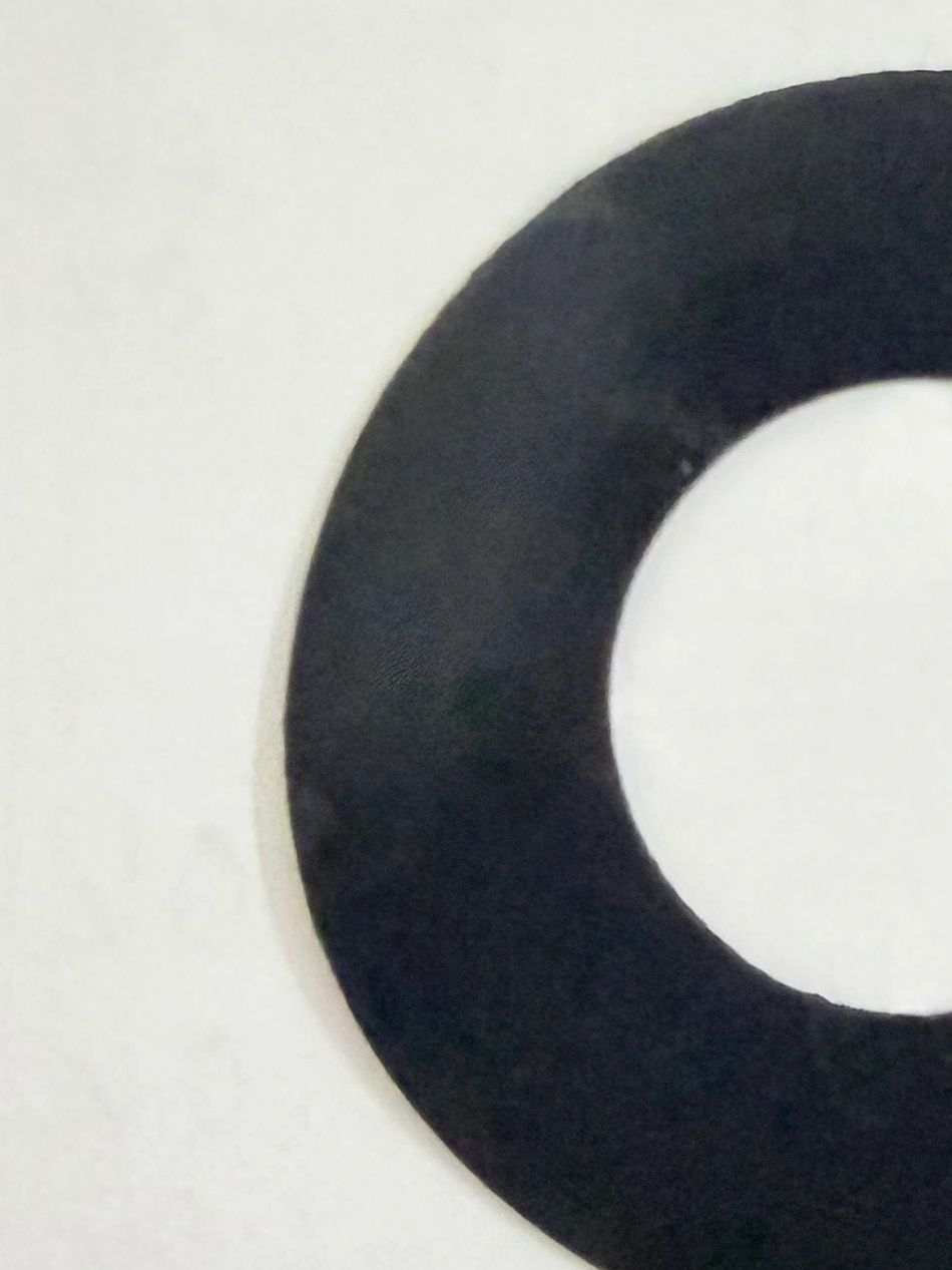 Close-up of a black circular object with a white center on a white background.