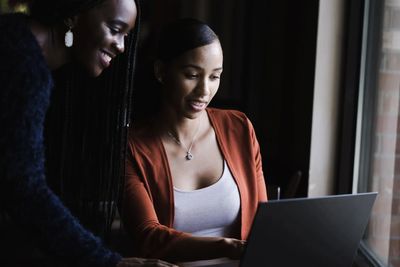 Two women looking at a laptop and smiling because they found a bookkeeping service in Nashville TN