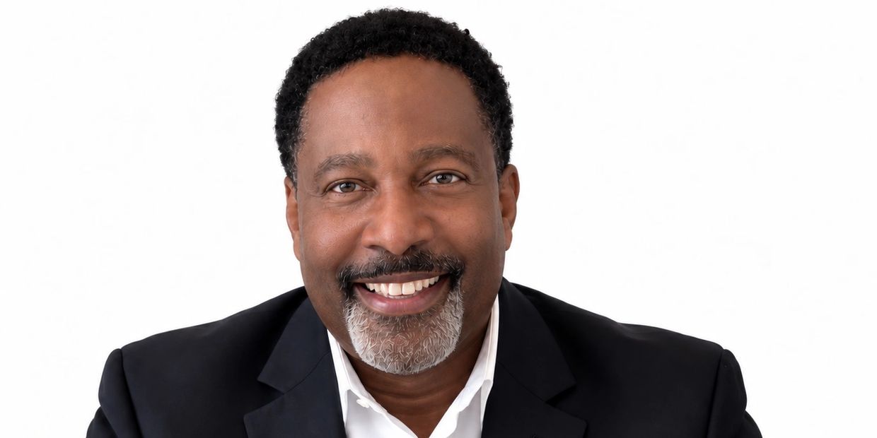 Smiling man in suit with white background.