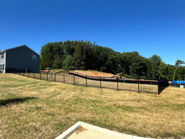 HOA approved black aluminum ornamental fence in the yard. 
