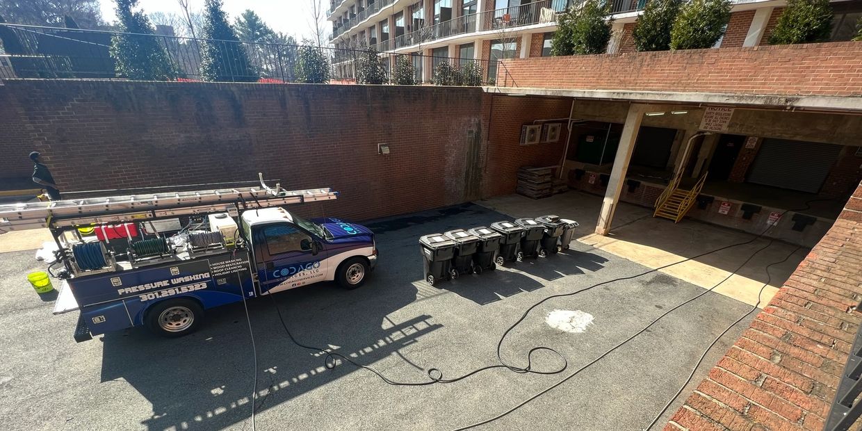 A pressure washing truck set up to clean a commercial building and loading dock 