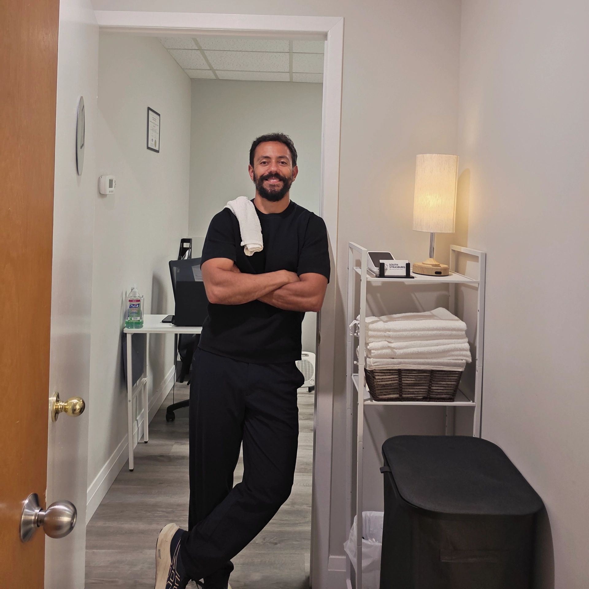 Man standing in a clean, organized room with folded towels.