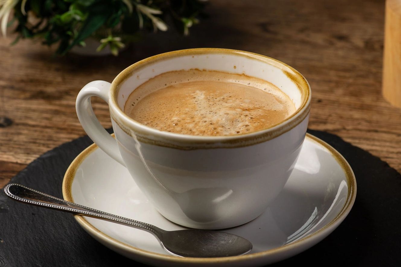 Cup of coffee with a spoon on a saucer.