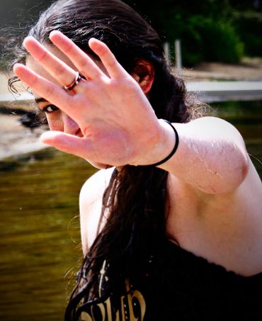 girl with hand up peaking eye, wet from water