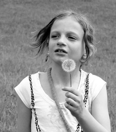 black and white, child with dandelion  waiting on wind