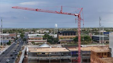 Construction site with crane over city buildings.