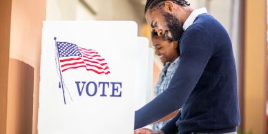 Two people casting their votes at a polling station.