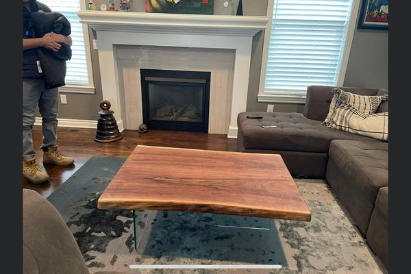 Live Edge coffee table from Walnut with glass legs to highlight the beauty of the wood.