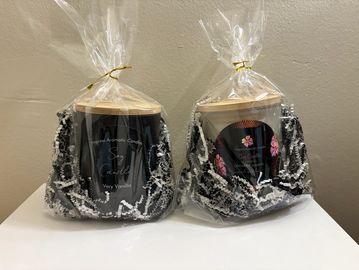 Two wrapped black candles with wooden lids.