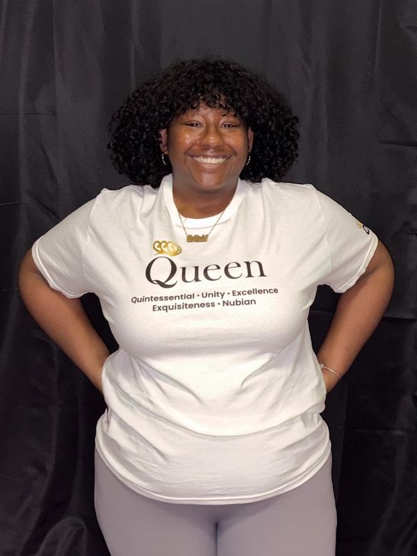Smiling woman wearing a white t-shirt with empowering text.