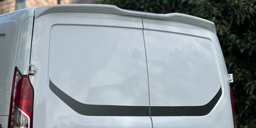 Rear view of a white van with a black graphic stripe.