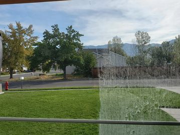 half cleaned window, green lawn, blue sky 