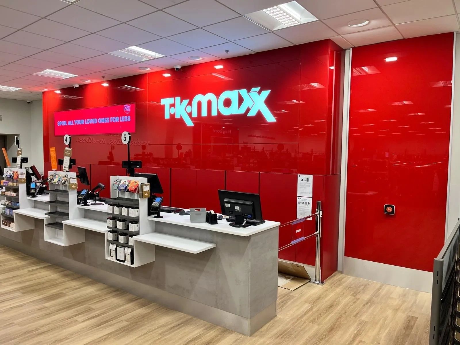 Empty Tk Maxx checkout area with red walls.