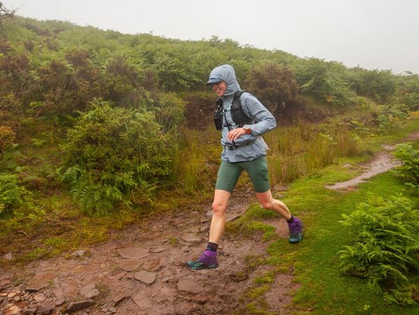 Runner enjoying a trail descent in the rain