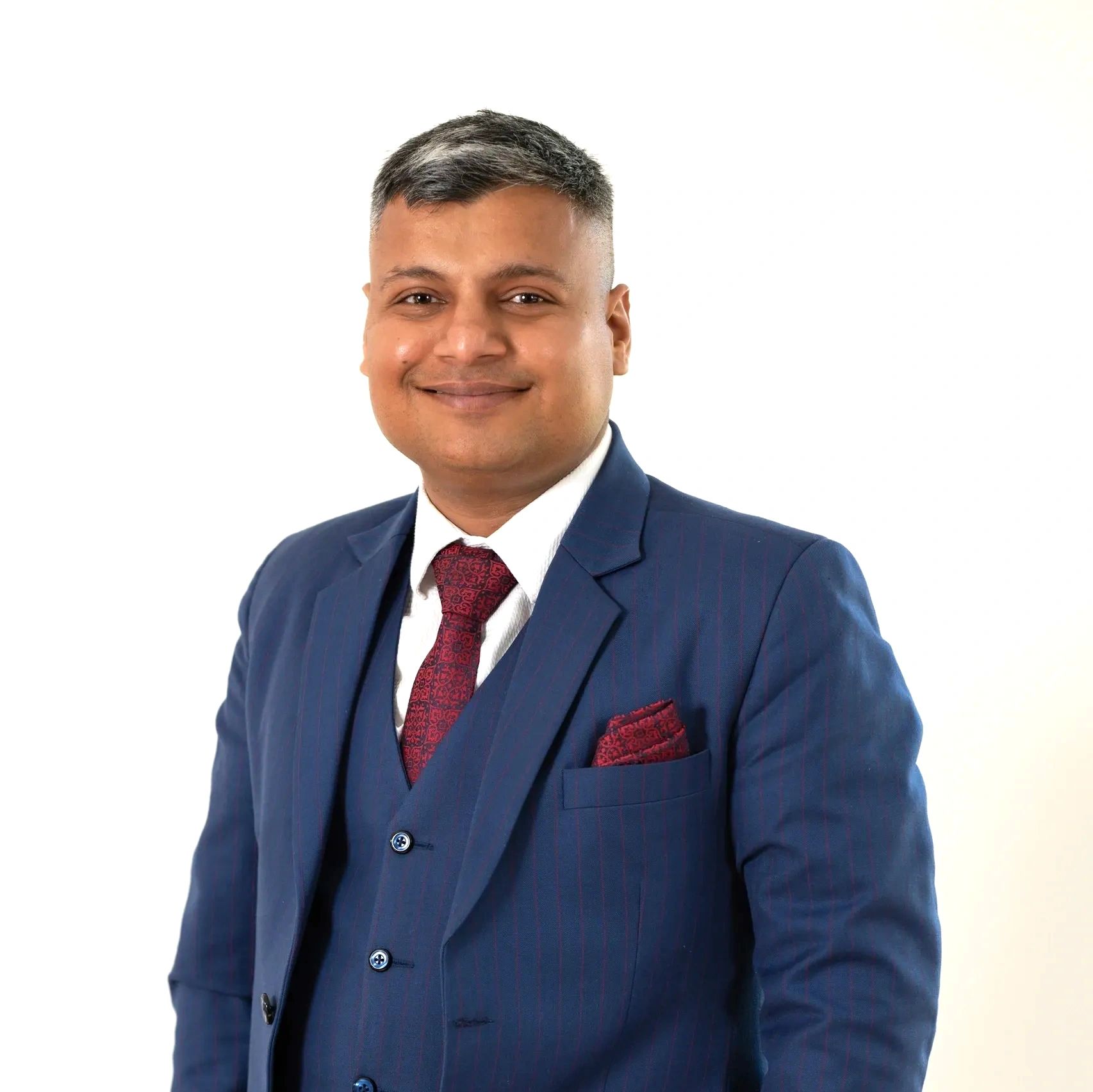 Man in a blue suit smiling confidently.