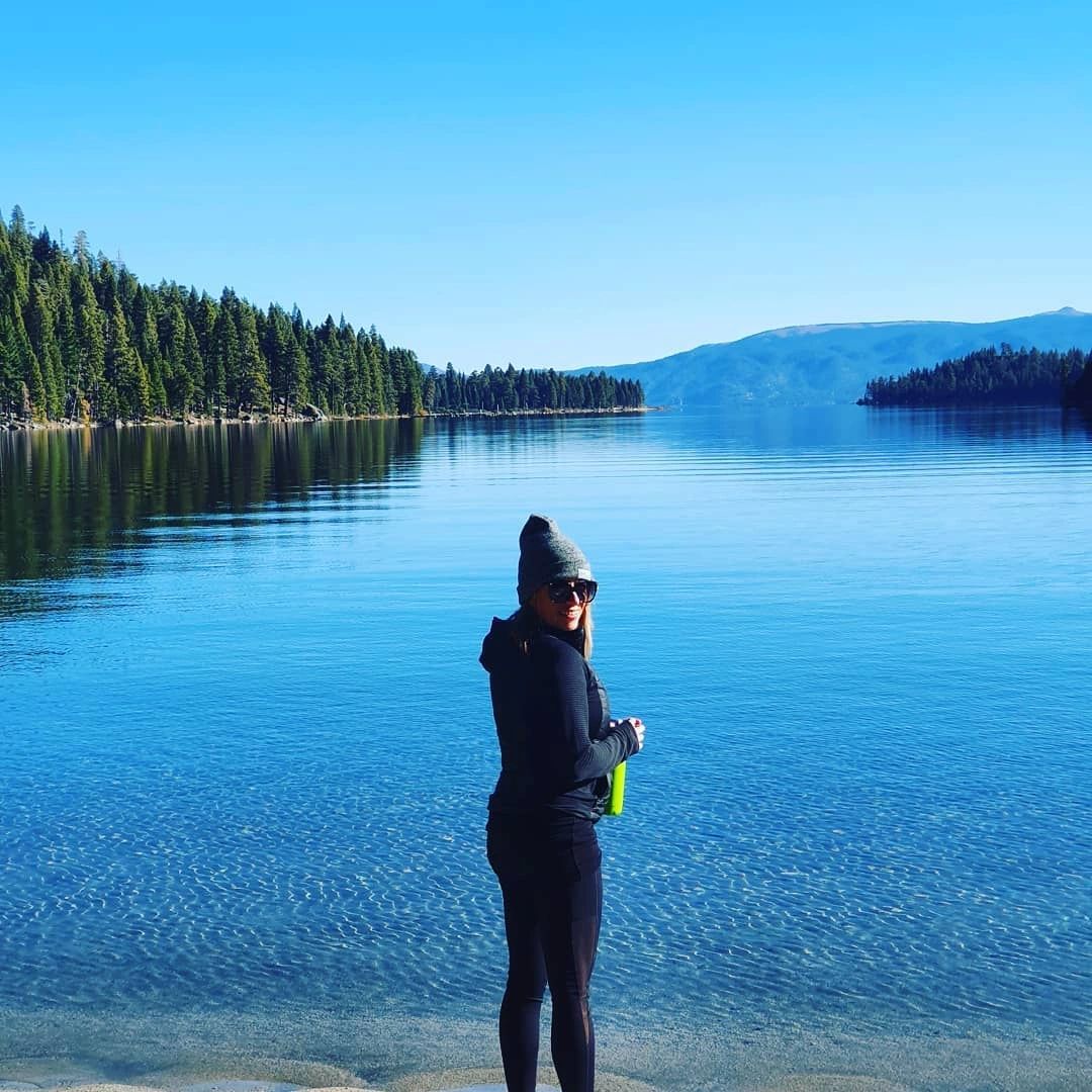Jade standing in a calm lake surrounded by forest