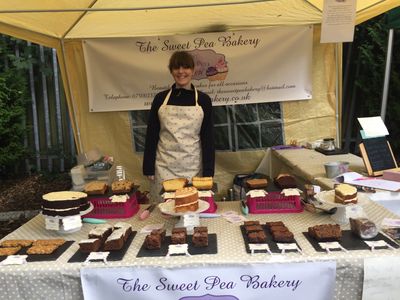 A person standing at a baking counter with cakes 