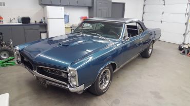 Blue vintage Pontiac GTO inside a garage.