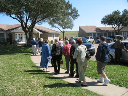 People walking on a sidewalk in a residential area.